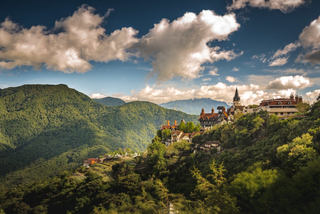 Bhutan - 7 Days 8 aerial shot small village hill surrounded by forested mountains